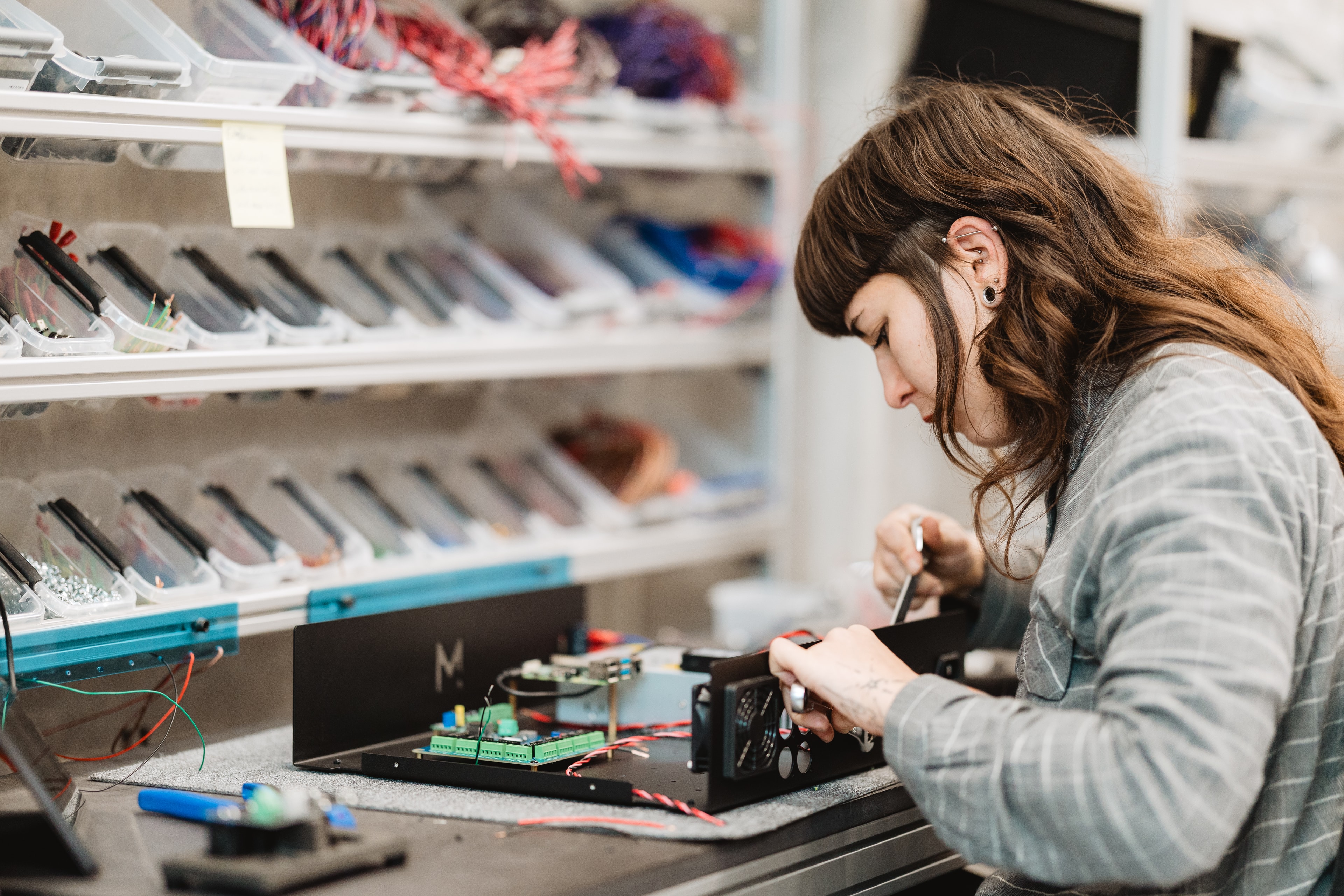 Jenifer assembling a control unit box in the Mekanika production workshop