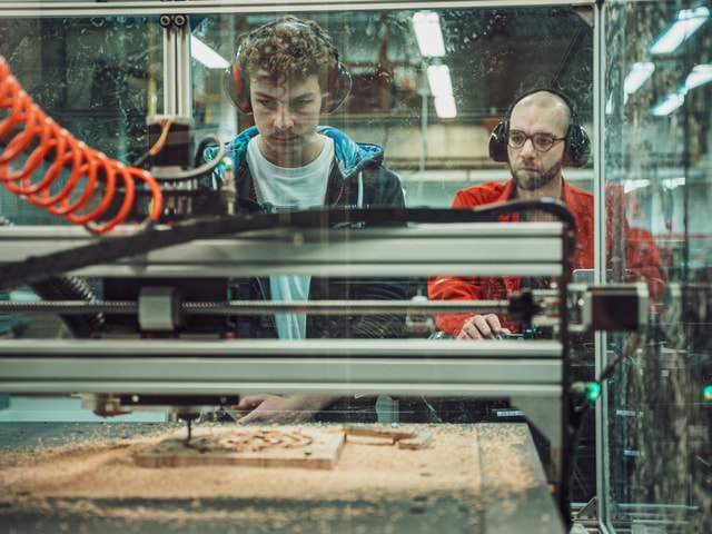 Two people working on a Pro CNC at ECAM 