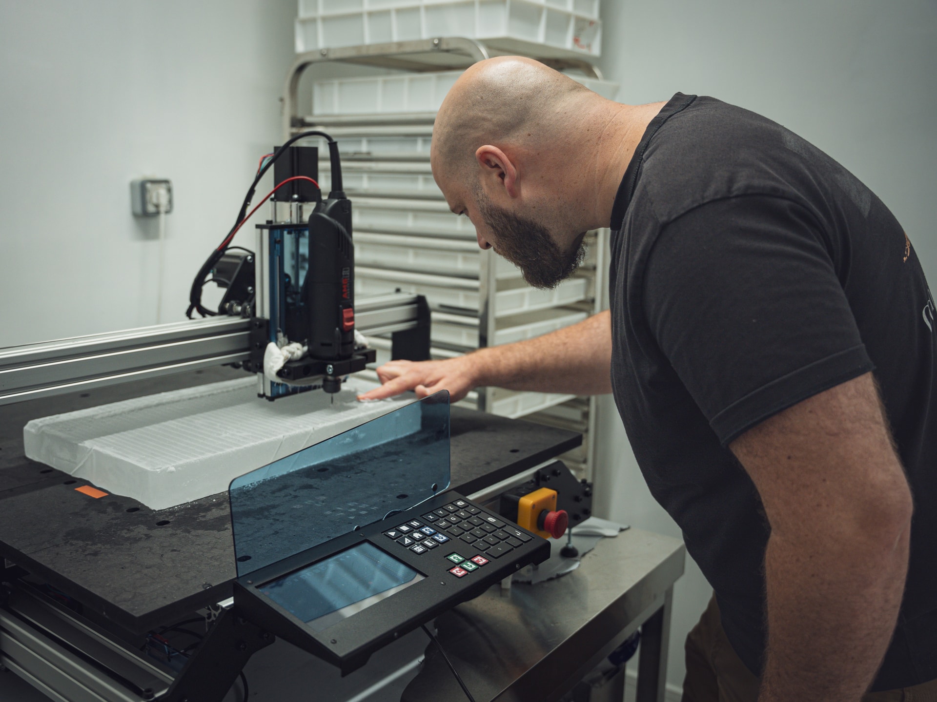 Mekanika Evo CNC milling machine milling logos on a clear ice slab and the operator checking the quality