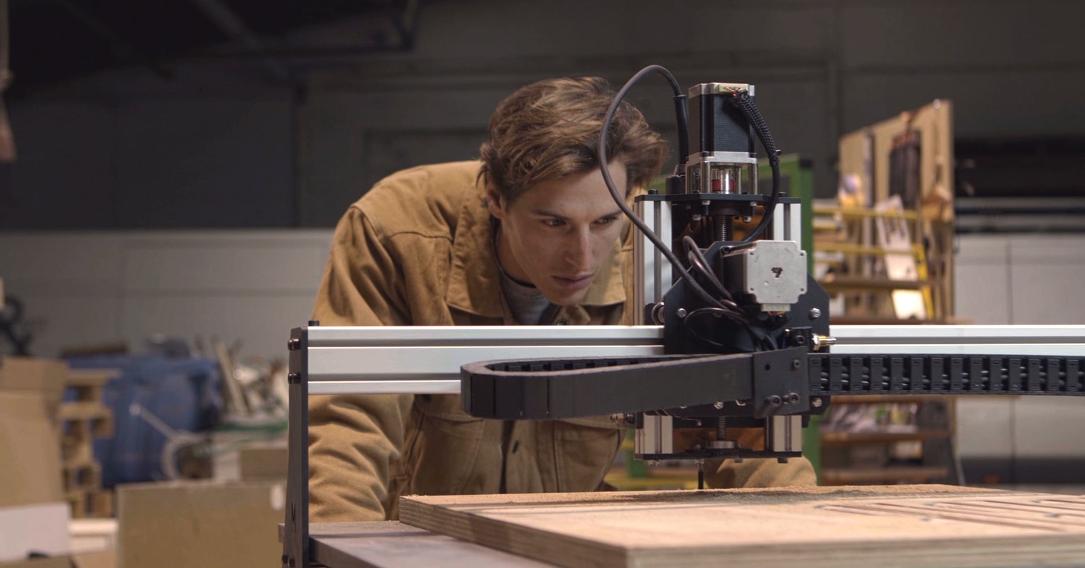 A person looking closely at a CNC machine