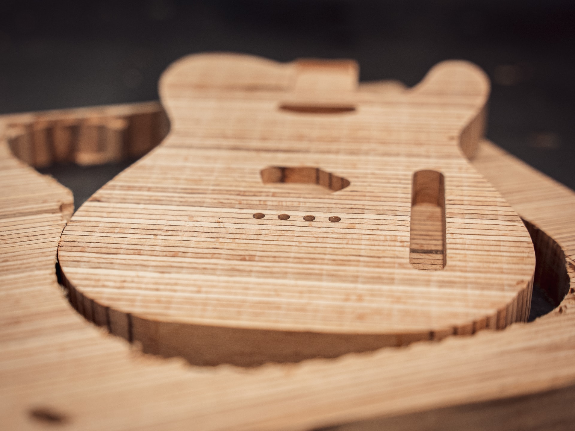 Wooden electric guitar body that has just been milled on a CNC