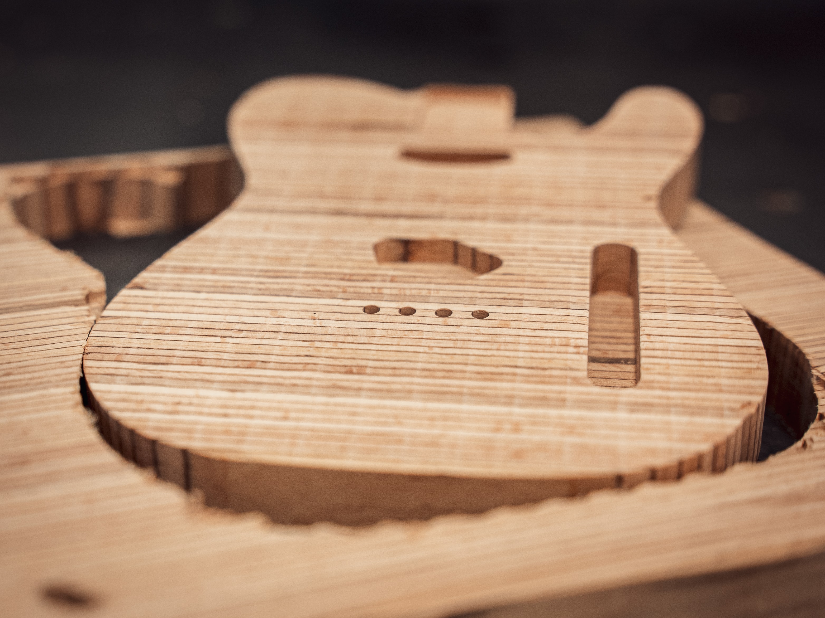 Wooden electric guitar body that has just been milled on a CNC