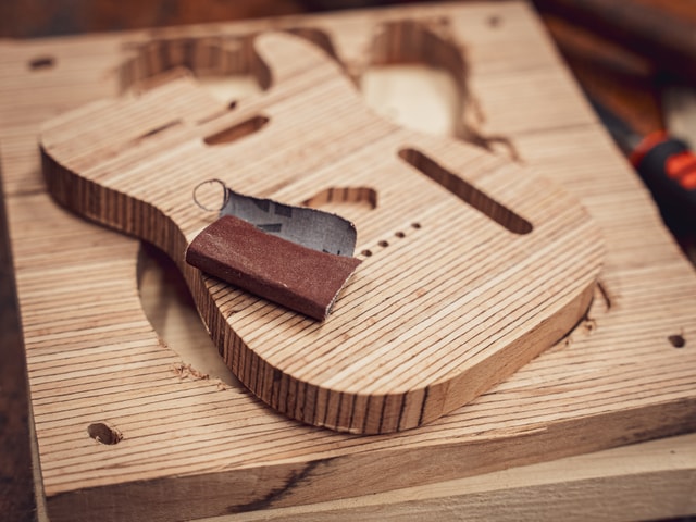 CNC milled electric guitar body and sanding block and paper