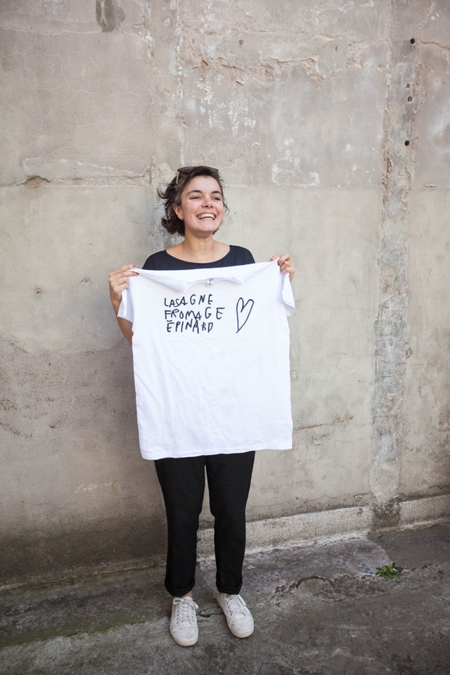 Woman holding her t-shirt that says "Lasagne fromage épinard" made on a Mekanika screen printing press