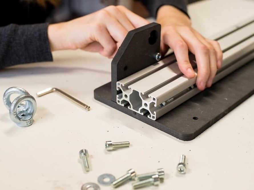 Two hands assembling the screen printing monochrom press kit 