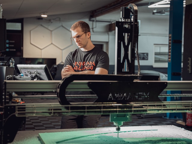 CNC operator observing a Mekanika Fab Cnc milling machine milling foam in a car workshop