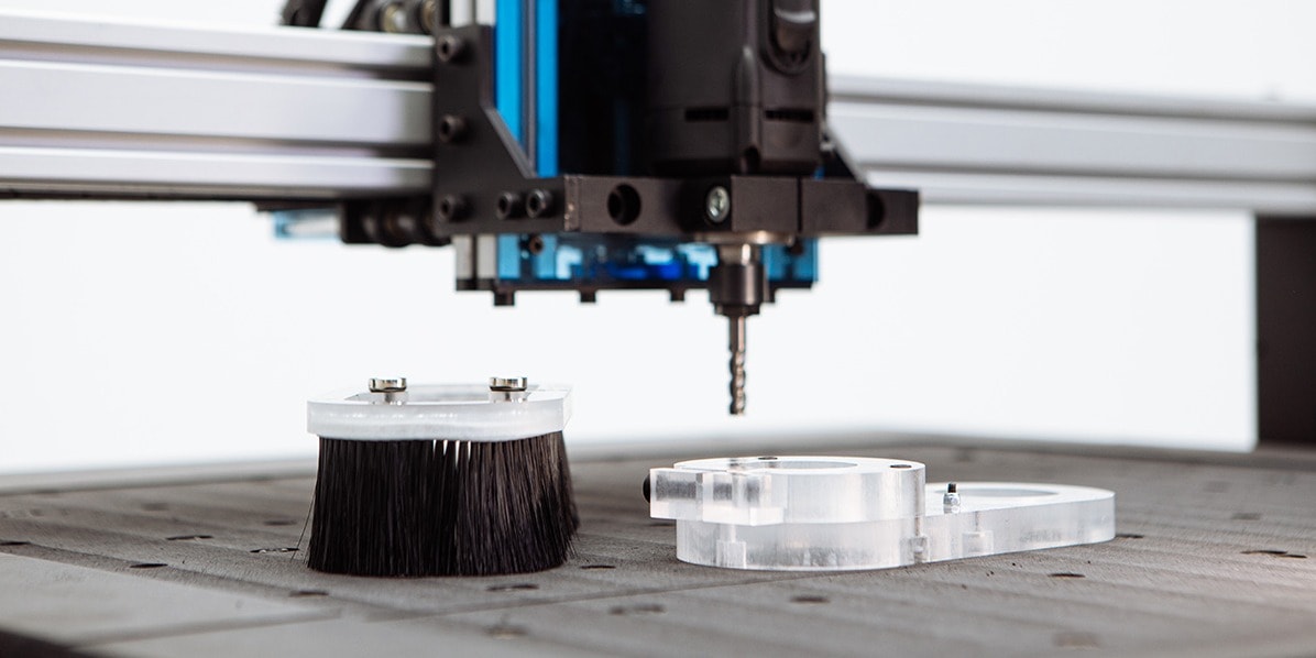 Evo close up on the endmill and the dust shoe parts placed on the spoilerboard