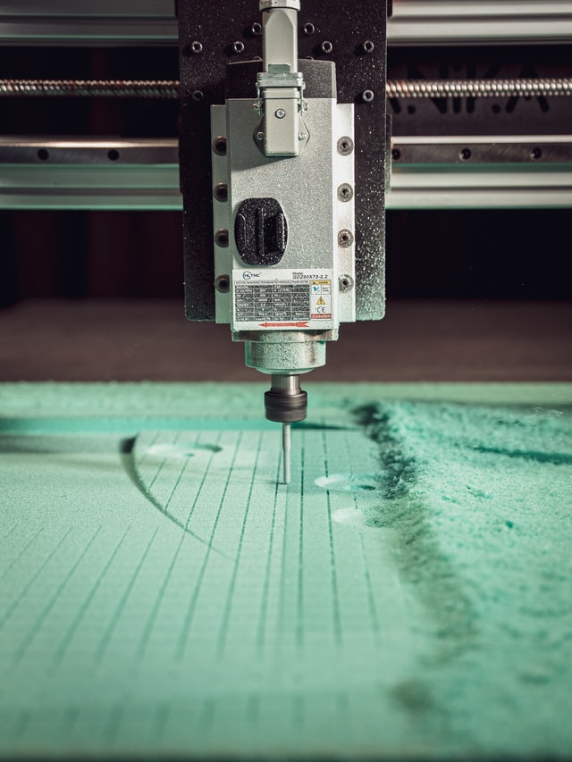Closeup of a mekanika Fab cnc milling machine's spindle and end mill milling in green foam to create a mold for carbon fiber
