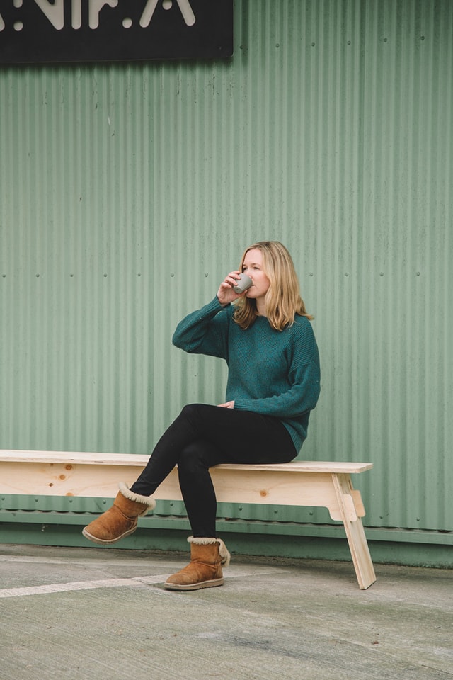 Delphine drinking a coffee on a bench made with the Mekanika  Fab