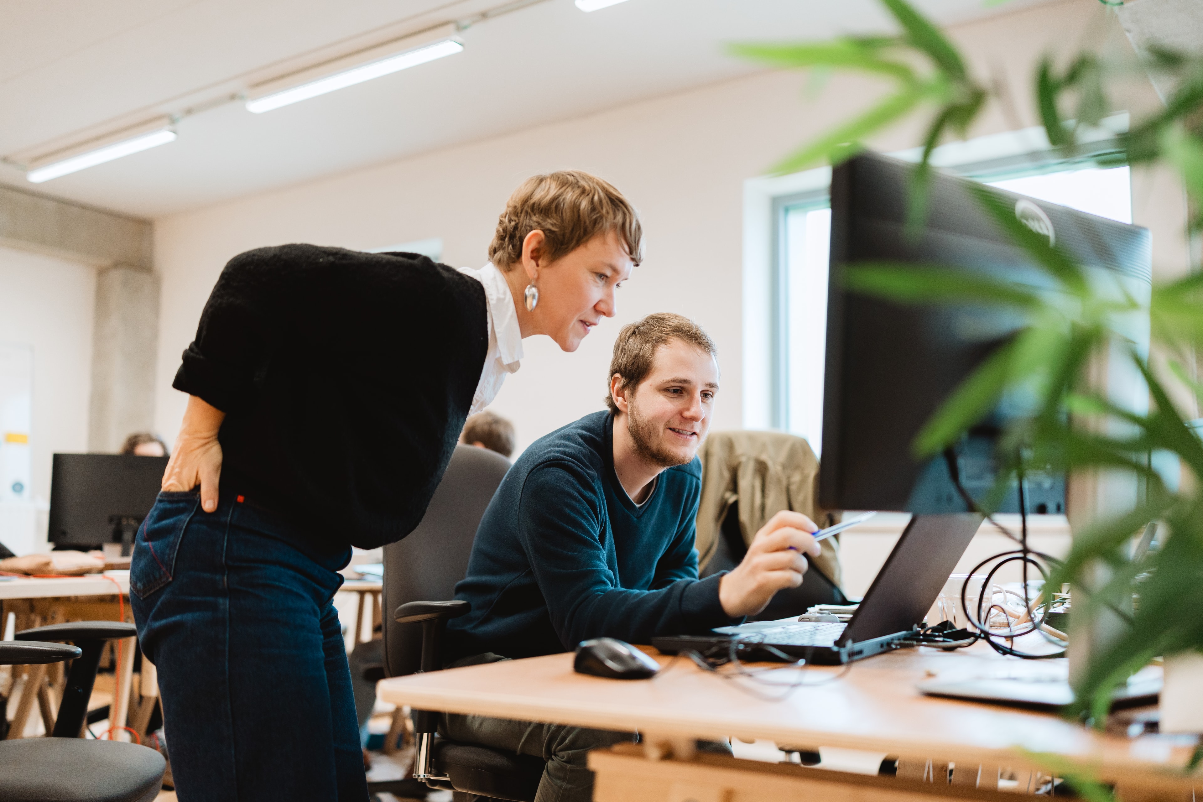 Mekanika employees discussing about a case in front a computer screen in the office